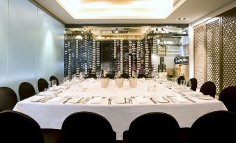 a dining table set for a formal dinner , with multiple wine glasses and silverware arranged neatly on the table at Gambaro Hotel Brisbane
