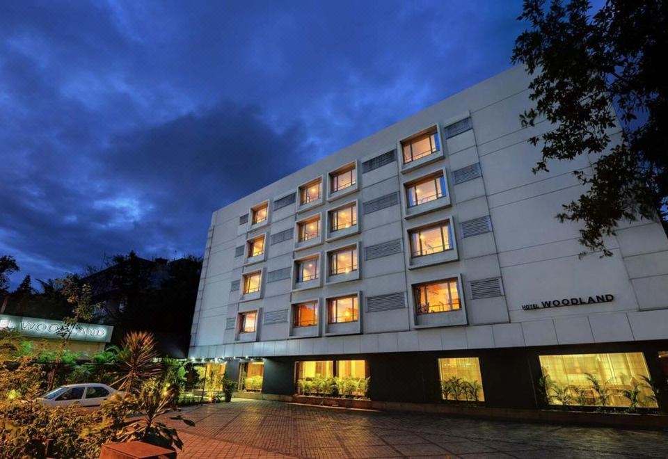 a large building with multiple windows and doors , lit up at night , surrounded by trees at Hotel Woodland