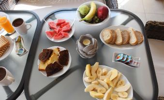 a table with various fruits and bread items , including watermelon slices and slices of bread at Sofotel