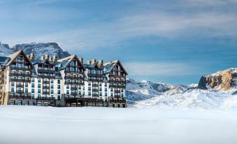 a large , snow - covered mountain with a hotel in the foreground and snow - covered ski slopes in the background at Park Chalet, Shahdag, Autograph Collection