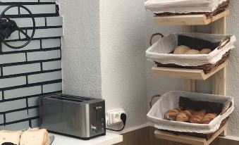 a microwave , toaster , and three baskets of food are hanging on a wall in a room at El Malecon