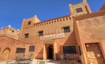 "the exterior of a building with a sign that says "" bagdad cafe "" and several tables outside" at Guest House Bagdad Café