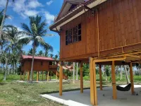 Traditional Thai wooden house on stilts set in a coconut orchard near the beach