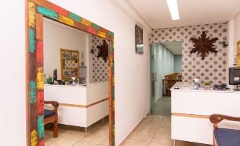a room with a colorful mirror on the wall and a desk with a chair at Pousada Tesouro de MInas