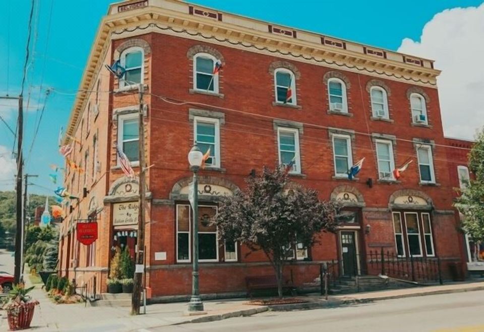 a brick building on a city street , with a tree in front of the building at The Hotel Belvidere