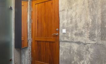 a wooden door with a doorknob and hinges is set in a concrete wall next to a gray door at Klettar Tower Iceland