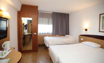 a hotel room with two beds , one on the left and one on the right side of the room at Travelodge Barcelona del Valles