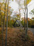 A modern A-frame, nestled in the woods with relaxing outdoor spaces and firepit.