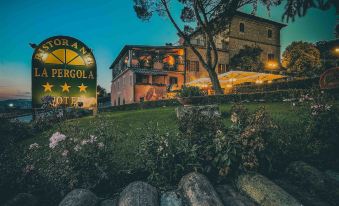 "a large building with a sign that says "" monerolia "" is surrounded by rocks and plants" at Hotel Ristorante la Pergola