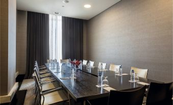 a conference room with a long table , chairs , and water bottles set for a meeting at Hotel Baia