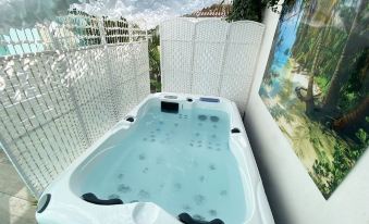 a white bathtub with blue water and bubbles is in a room with a wooden fence at The Corner Properties