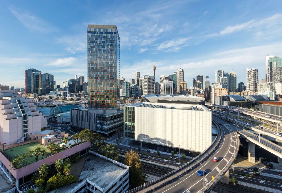 a city skyline with a tall building and a large white building in the center at Oaks Sydney Goldsbrough Suites