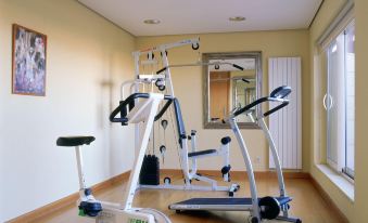 a room with two exercise bikes , one on the left side and the other on the right side of the room at Parador de Salamanca