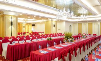 a large banquet hall with long tables covered in red tablecloths and chairs arranged for a formal event at Tien Loc Palace Hotel