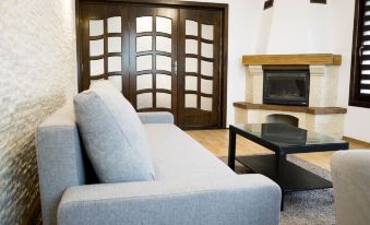 a modern living room with a blue couch , a black coffee table , and a fireplace at Nest