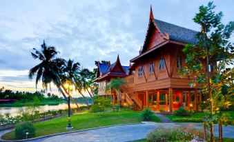 a large wooden building situated on the side of a road , overlooking a body of water at RK Riverside Resort & Spa (Reon Kruewal)