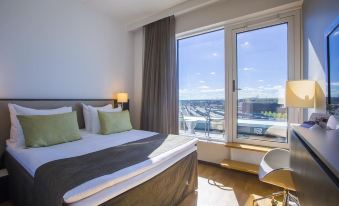 a hotel room with a large bed and a window overlooking a body of water at Radisson Blu Hotel Uppsala