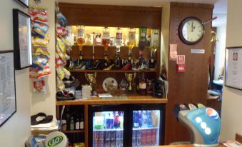 a bar area with various items such as beer taps , beer bottles , and awards on display at The Shoes