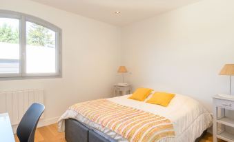 a bed with a yellow and white striped blanket is in a room with wooden floors at Dade