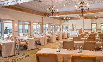 a large dining room with multiple tables and chairs set up for a formal event , possibly a wedding reception at Wequassett Resort and Golf Club