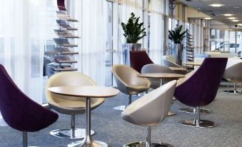 a modern office space with multiple chairs and tables arranged in a dining area , creating an inviting atmosphere at Mercure Paris Ivry Quai de Seine