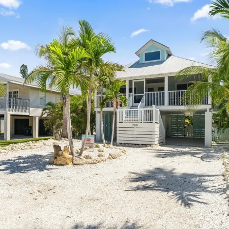 Charming cottage with heated pool, tropical landscaping in prime location.