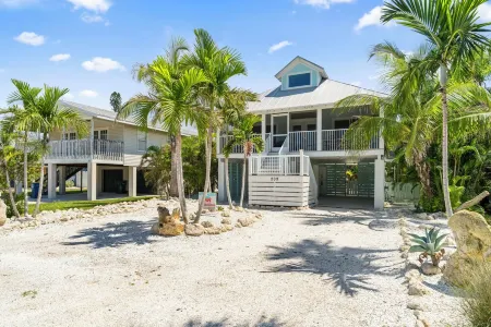 Charming cottage with heated pool, tropical landscaping in prime location.