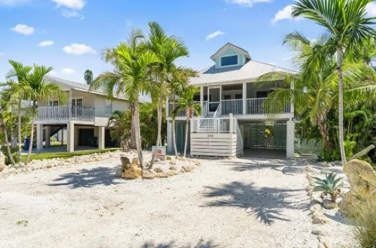 Charming cottage with heated pool, tropical landscaping in prime location.