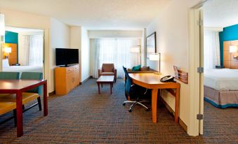 a hotel room with a living area , featuring a couch , desk , and tv . also a chair in the room at Residence Inn Bridgewater Branchburg