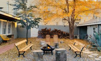 a courtyard with a fire pit surrounded by wooden benches , creating a cozy and inviting atmosphere at The Lincoln Marfa