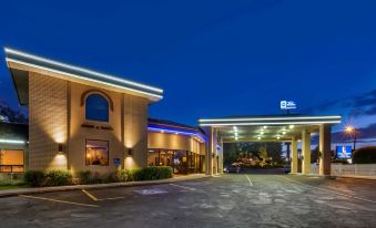 a blue ridge inn and suites hotel at night , with its entrance and parking lot illuminated at Best Western Dunmar Inn