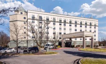 a large , modern hotel building with multiple floors and balconies , surrounded by trees and cars parked outside at Comfort Inn Largo-Washington DC East