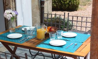a dining table set with plates , glasses , and a pitcher of orange juice on a patio at Chateau Latour