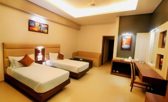 a modern hotel room with two beds , a couch , and a television , all neatly arranged at Imperial Heights