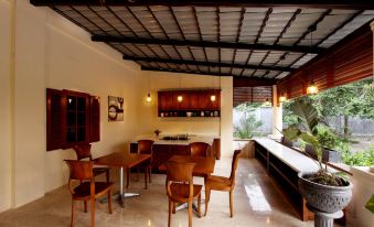 a well - appointed living room with wooden furniture , including a dining table , chairs , and a couch at Griya Gendhis Saraswati