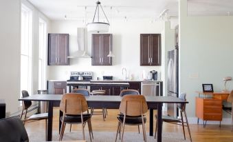 a large dining room with wooden chairs and a long dining table surrounded by brown cabinets at Hart House Hotel