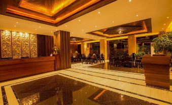 a modern hotel lobby with marble floors , wooden furniture , and a reception desk in the center at The Home Hotel