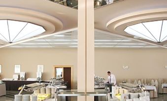 a dining room with a buffet table filled with various food items , including bowls , cups , and utensils at Hotel Olympia