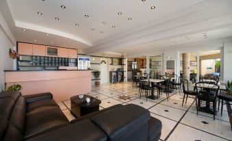 a spacious living room with a black leather couch and chairs , a dining area , and a bar at Sunrise Apartments