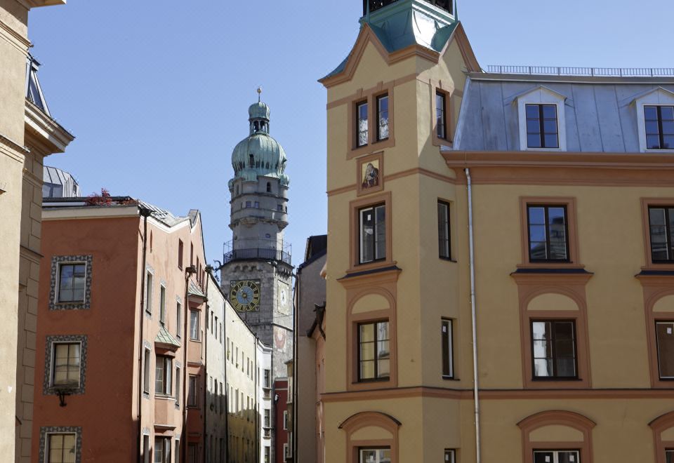 a tall building with a clock tower is located in the middle of a street at Hotel Innsbruck