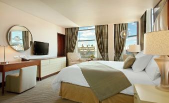 a modern hotel room with a large bed , beige curtains , and a balcony offering views of the city at Hilton Windhoek