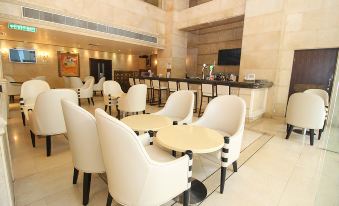 The restaurant features white chairs and tables in the center, creating an open concept dining experience at Holiday Inn MACAU by IHG