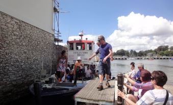 a group of people are standing on a dock next to a boat , possibly waiting for someone to board at Lakeside