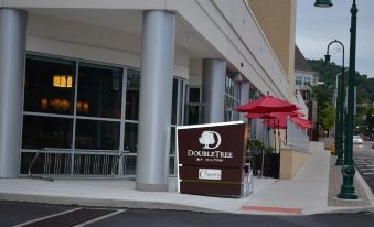 a brown sign for the doubletree by hilton hotel with red umbrellas in front of it at DoubleTree by Hilton Reading