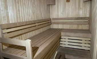 a wooden sauna with benches and a heater , providing a relaxing atmosphere for the occupants at Sunrise Beach Villa