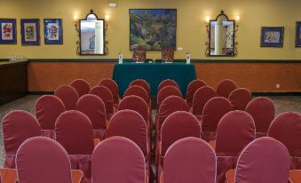 a conference room with rows of chairs arranged in a semicircle , facing a podium and surrounded by paintings on the wall at Parador de Cangas de Onis