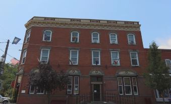 a brick building with multiple windows , located on a city street under a clear blue sky at The Hotel Belvidere