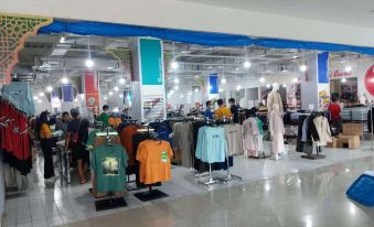 a large clothing store with aisles filled with various types of clothes , including shirts , pants , and dresses at Pematang Siantar