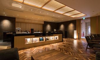 a modern hotel lobby with a reception desk and a staircase leading to the second floor at Okuhita Onsen Umehibiki