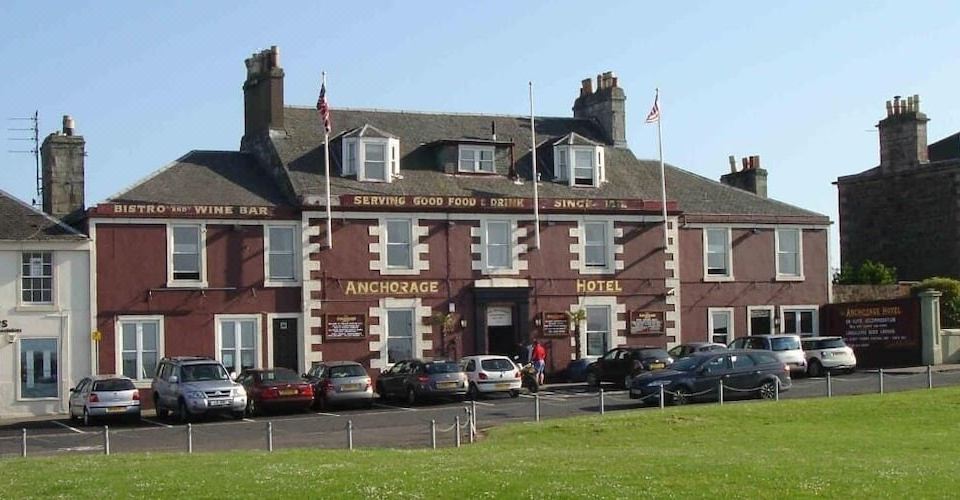 "a large red brick building with the words "" anchor & base hotel "" written on it" at The Anchorage Hotel